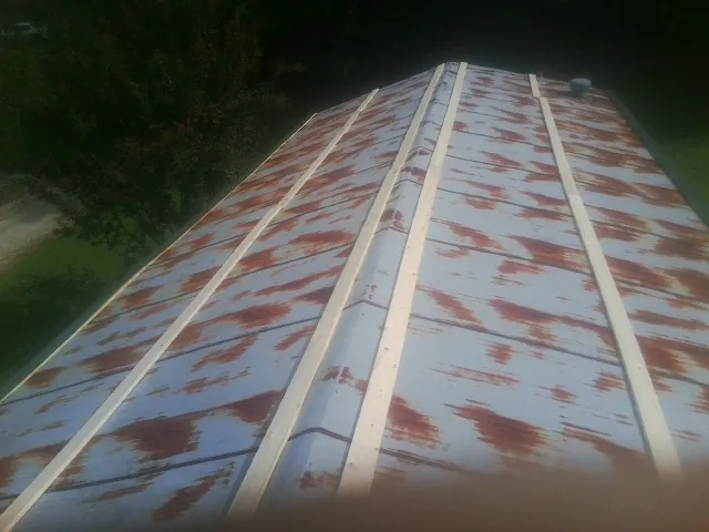Rusted metal roof panels with new wood purlins before replacement — Storm Damage Roof Repair in Croghan by Roofing Brothers