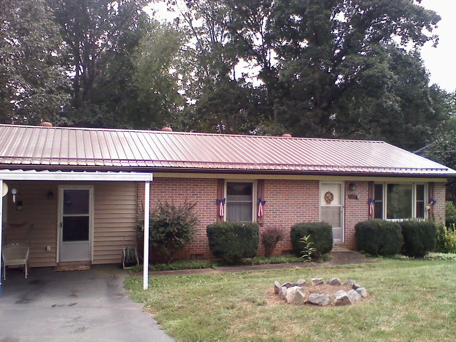 Bronze metal roof and carport on a brick ranch home — Roof Repair work by our crew in Croghan