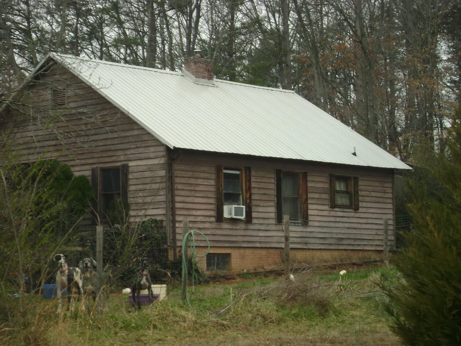 White metal roof on an old wood sided farmhouse, from a Metal Roof Installation job in Croghan
